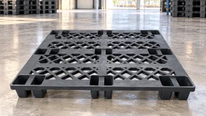 Black nine-leg grid plastic pallet in a warehouse staging area